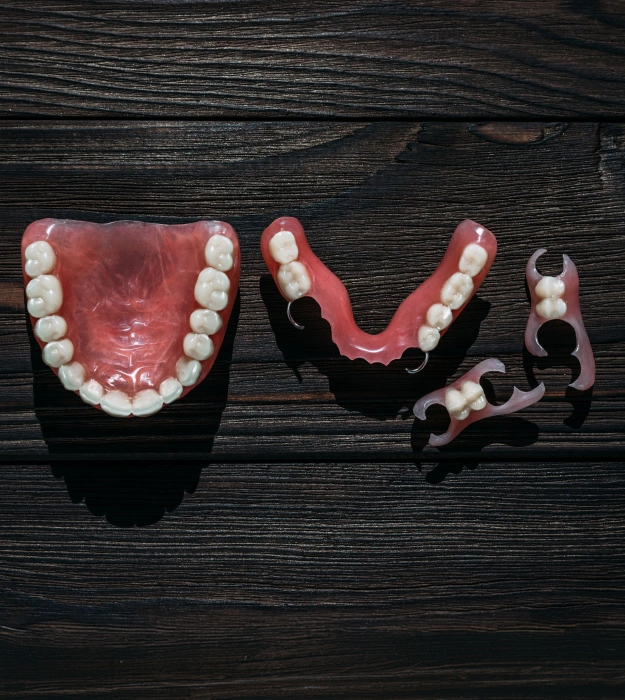 Partial denture prosthetic displayed on a dark wooden surface