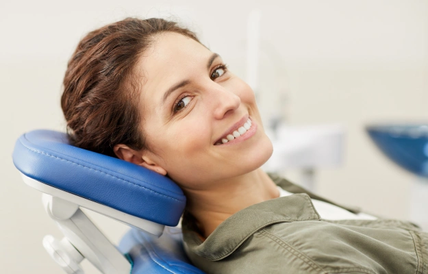 Young woman smiling while seated in a dental chair during a visit