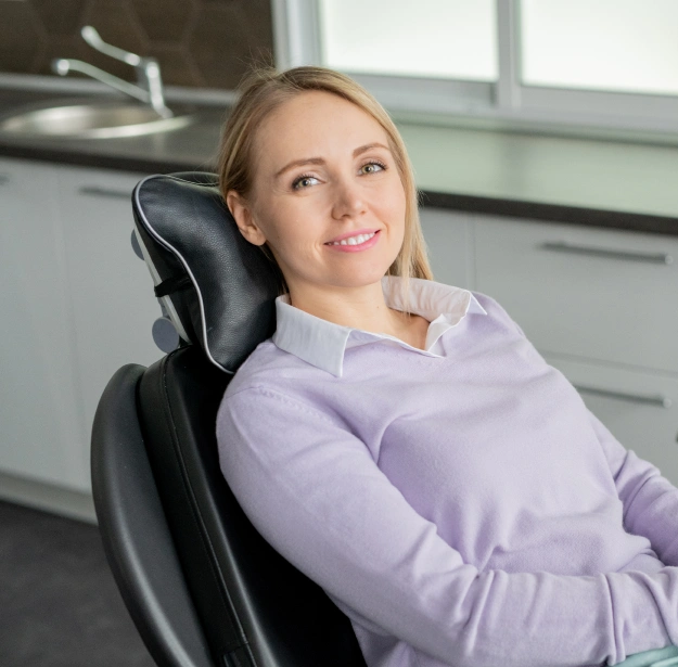 Woman smiling while seated in a dental chair during a periodontal disease consultation
