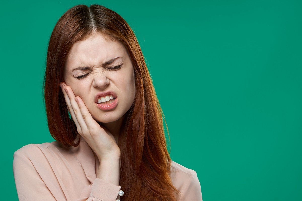 Woman experiencing severe tooth pain and seeking emergency dental care