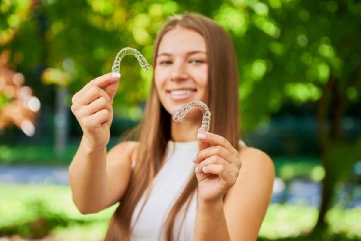 Woman holding Invisalign clear aligners for a straighter smile in Round Rock, TX